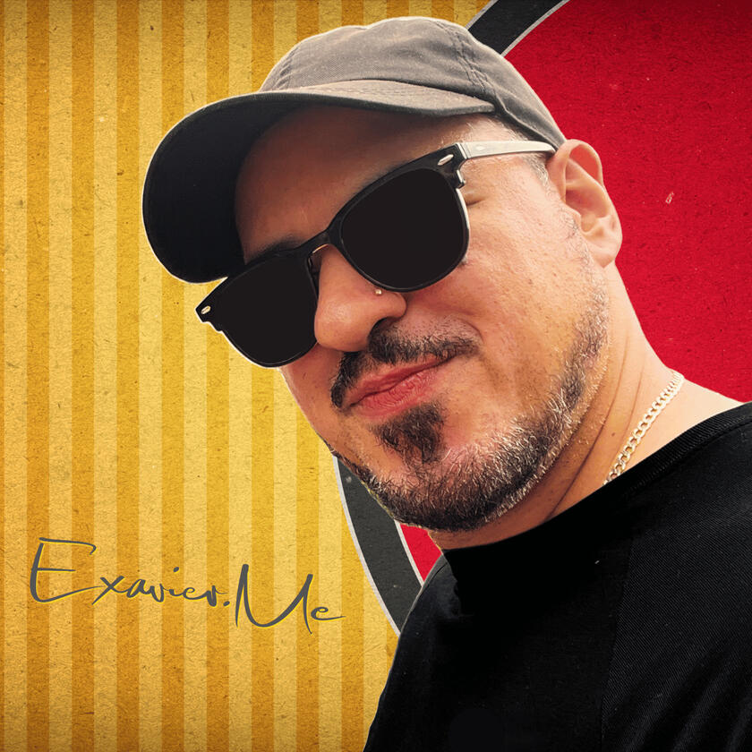 Exavier.Me Gallery Image 6 Close up image of Exavier Me wearing a cap forward and wearing sun glasses. A signature of Exavier's name is located in the lower left corner of the image.